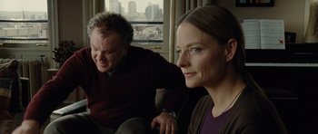 Movie still from “Carnage” (2011), directed by Roman Polanski – A man and a woman sitting on a couch in front of a window; Close Up shot, Over the shoulder angle