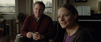 Movie still from “Carnage” (2011), directed by Roman Polanski – A man and a woman sitting next to each other holding a cup; Close Up shot, Over the shoulder angle