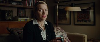 Movie still from “Carnage” (2011), directed by Roman Polanski – A woman sitting on a couch holding a coffee mug; Close Up shot, Over the shoulder angle