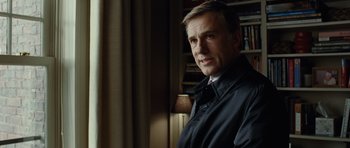 Movie still from “Carnage” (2011), directed by Roman Polanski – A person wearing a suit and tie; Close Up shot, Low angle