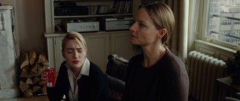 Movie still from “Carnage” (2011), directed by Roman Polanski – Two women sitting in front of each other in a living room; Medium shot, Over the shoulder angle