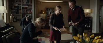 Movie still from “Carnage” (2011), directed by Roman Polanski – A group of people standing in a living room eating pizza; Wide shot, High angle