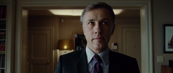 Movie still from “Carnage” (2011), directed by Roman Polanski – A person wearing a suit and tie; Close Up shot, Low angle
