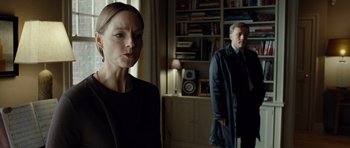 Movie still from “Carnage” (2011), directed by Roman Polanski – A woman and a man standing in front of a bookcase; Medium shot, Over the shoulder angle
