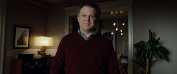 Movie still from “Carnage” (2011), directed by Roman Polanski – A man standing in front of a mirror in a living room; Medium shot, Low angle