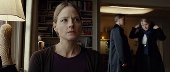 Movie still from “Carnage” (2011), directed by Roman Polanski – A woman standing in front of a man in front of a bookcase; Close Up shot, Over the shoulder angle