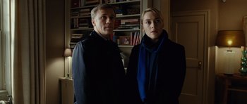 Movie still from “Carnage” (2011), directed by Roman Polanski – A man and a woman standing next to each other in a room; Medium shot, Low angle