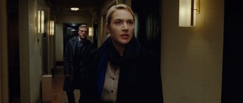 Movie still from “Carnage” (2011), directed by Roman Polanski – A woman wearing a black jacket and a blue scarf; Medium shot, Over the shoulder angle