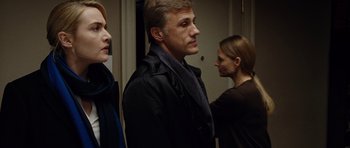 Movie still from “Carnage” (2011), directed by Roman Polanski – A man and two women standing next to each other in a room; Close Up shot, Over the shoulder angle