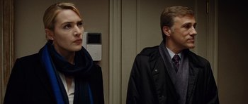 Movie still from “Carnage” (2011), directed by Roman Polanski – A man and a woman standing next to each other; Close Up shot, Over the shoulder angle