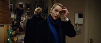 Movie still from “Carnage” (2011), directed by Roman Polanski – A woman in a black coat and blue scarf; Close Up shot, Over the shoulder angle