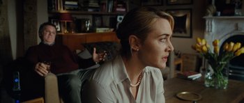 Movie still from “Carnage” (2011), directed by Roman Polanski – A person wearing a pearl necklace; Close Up shot, Over the shoulder angle