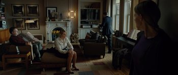 Movie still from “Carnage” (2011), directed by Roman Polanski – A woman sitting on a couch next to a man; Wide shot, High angle