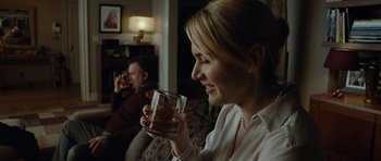 Movie still from “Carnage” (2011), directed by Roman Polanski – A woman holding up a glass of whiskey; Close Up shot, Over the shoulder angle