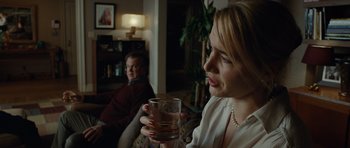 Movie still from “Carnage” (2011), directed by Roman Polanski – A woman holding a glass in her right hand; Close Up shot, Over the shoulder angle