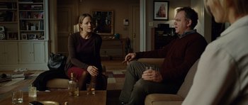 Movie still from “Carnage” (2011), directed by Roman Polanski – A man and a woman sitting in a living room talking; Medium shot, Over the shoulder angle