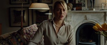 Movie still from “Carnage” (2011), directed by Roman Polanski – A woman wearing a beige shirt and a pearl necklace; Close Up shot, Over the shoulder angle
