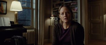Movie still from “Carnage” (2011), directed by Roman Polanski – A woman sitting in front of a book shelf; Medium shot, Over the shoulder angle