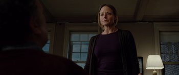 Movie still from “Carnage” (2011), directed by Roman Polanski – A woman standing in front of a window in a room; Medium shot, Low angle