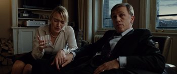 Movie still from “Carnage” (2011), directed by Roman Polanski – A man and a woman sitting next to each other on a couch; Medium shot, High angle
