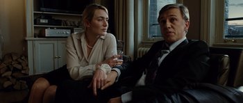 Movie still from “Carnage” (2011), directed by Roman Polanski – A woman sitting next to a man holding a wine glass; Medium shot, Over the shoulder angle