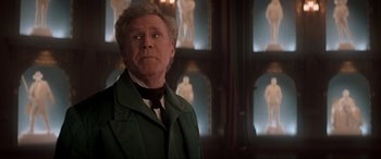 Movie still from “Spirited” (2022), directed by Sean Anders – An older man in a green jacket and a black tie; Medium shot, Over the shoulder angle