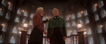 Movie still from “Spirited” (2022), directed by Sean Anders – Two men standing next to each other in front of a building; Medium shot, Low angle