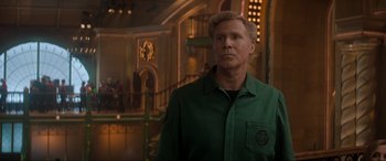 Movie still from “Spirited” (2022), directed by Sean Anders – A man in a green shirt standing in front of a building; Medium shot, Over the shoulder angle