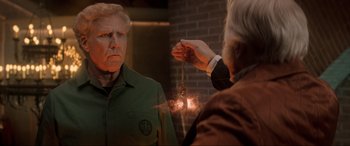 Movie still from “Spirited” (2022), directed by Sean Anders – An older man is looking in the mirror while a younger man is holding a key chain; Medium shot, Over the shoulder angle