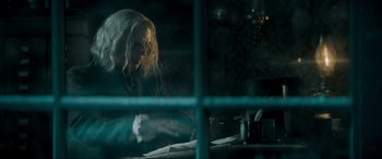 Movie still from “Spirited” (2022), directed by Sean Anders – A woman sitting at a table looking at papers; Medium shot, Over the shoulder angle