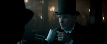 Movie still from “Spirited” (2022), directed by Sean Anders – A man wearing a top hat and holding a cup; Close Up shot, Over the shoulder angle