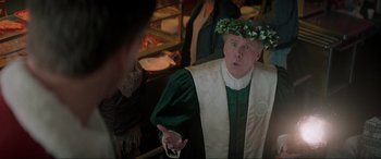 Movie still from “Spirited” (2022), directed by Sean Anders – A man wearing a wreath of ivy on his head; Medium shot, Over the shoulder angle