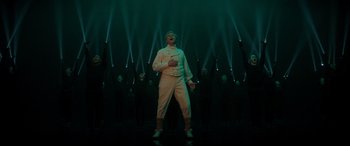 Movie still from “Spirited” (2022), directed by Sean Anders – A man standing in front of a group of people; Wide shot, Low angle