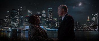Movie still from “Spirited” (2022), directed by Sean Anders – A man and a woman standing next to each other in front of a city skyline at night; Medium shot, Over the shoulder angle
