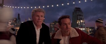 Movie still from “Spirited” (2022), directed by Sean Anders – A couple of men sitting next to each other on top of a building; Close Up shot, Over the shoulder angle