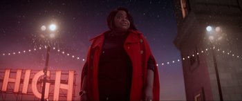 Movie still from “Spirited” (2022), directed by Sean Anders – A woman in a red coat standing in front of a night sky; Medium shot, Low angle