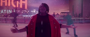 Movie still from “Spirited” (2022), directed by Sean Anders – A woman in a red coat standing in the snow; Medium shot, Low angle