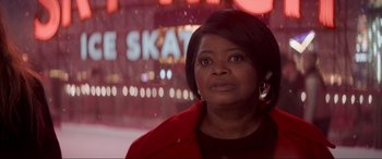 Movie still from “Spirited” (2022), directed by Sean Anders – A woman in a red coat is standing in front of a neon sign; Close Up shot, Over the shoulder angle
