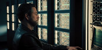 Movie still from “Spy Kids: Armageddon” (2023), directed by Robert Rodriguez – A man sitting in front of a window looking out; Medium shot, Over the shoulder angle