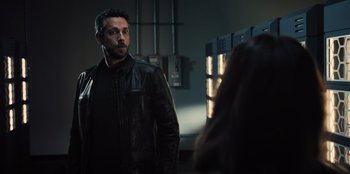 Movie still from “Spy Kids: Armageddon” (2023), directed by Robert Rodriguez – A man wearing a leather jacket standing next to a woman; Medium shot, Over the shoulder angle