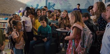 Movie still from “Spy Kids: Armageddon” (2023), directed by Robert Rodriguez – A group of children sitting around a table; Wide shot, High angle