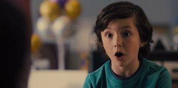 Movie still from “Spy Kids: Armageddon” (2023), directed by Robert Rodriguez – A young boy with a surprised look on his face; Close Up shot, Over the shoulder angle