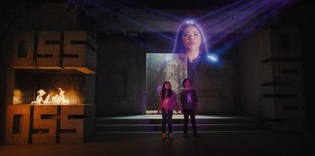 Movie still from “Spy Kids: Armageddon” (2023), directed by Robert Rodriguez – Two young girls standing in front of a projected image of a woman; Wide shot, Low angle