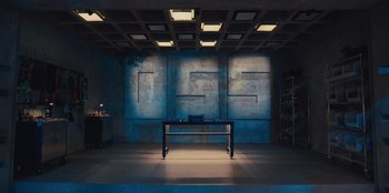 Movie still from “Spy Kids: Armageddon” (2023), directed by Robert Rodriguez – A table in front of a blue wall with lights on it; Extreme Wide shot, Overhead angle