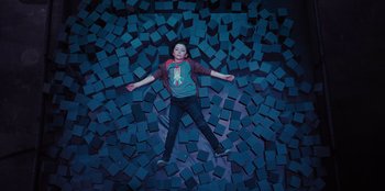 Movie still from “Spy Kids: Armageddon” (2023), directed by Robert Rodriguez – A boy laying on the ground surrounded by blocks; Wide shot, Overhead angle