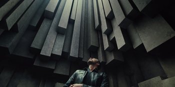 Movie still from “Spy Kids: Armageddon” (2023), directed by Robert Rodriguez – A man in black jacket looking up at the sky; Wide shot, Low angle