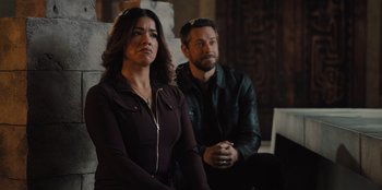 Movie still from “Spy Kids: Armageddon” (2023), directed by Robert Rodriguez – A woman and a man sitting next to each other; Medium shot, High angle