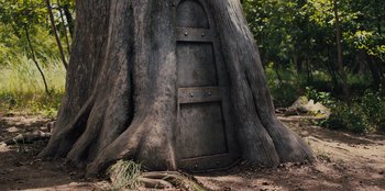 Movie still from “Spy Kids: Armageddon” (2023), directed by Robert Rodriguez – An old door in the middle of a tree trunk; Wide shot, Low angle
