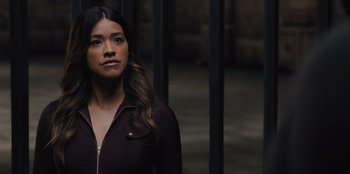 Movie still from “Spy Kids: Armageddon” (2023), directed by Robert Rodriguez – A woman standing in front of a metal gate; Close Up shot, Low angle