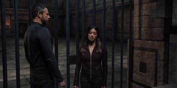 Movie still from “Spy Kids: Armageddon” (2023), directed by Robert Rodriguez – A woman standing next to a man in front of a gate; Medium shot, High angle